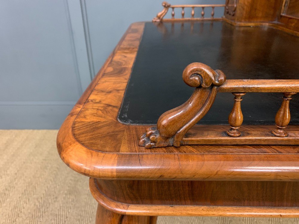 A 19th-century burr walnut bonheur du jour writing desk with a dark leather top, slender cabriole legs, and a gallery section featuring mirrors and small side cabinets. View XIX