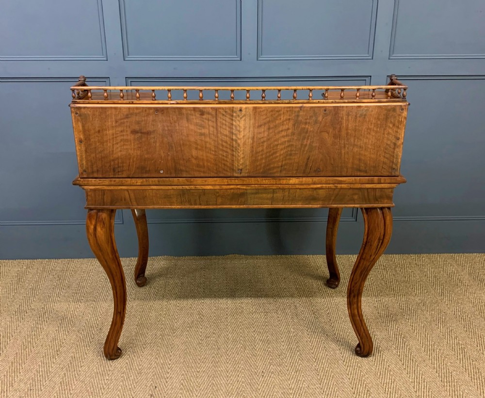 A 19th-century burr walnut bonheur du jour writing desk with a dark leather top, slender cabriole legs, and a gallery section featuring mirrors and small side cabinets. View XXI
