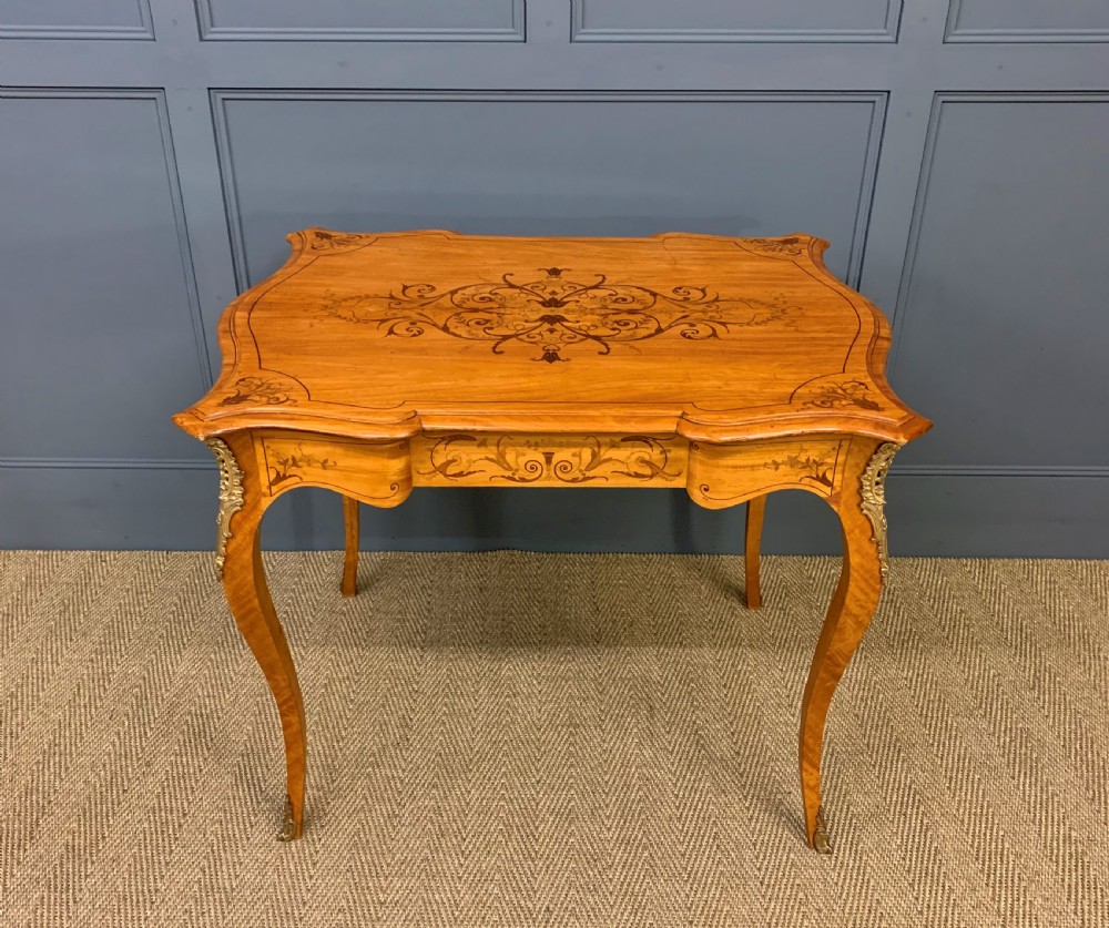 A 19th-century satinwood side table featuring floral marquetry inlay, serpentine edges, curved cabriole legs, and brass corner mounts. View II