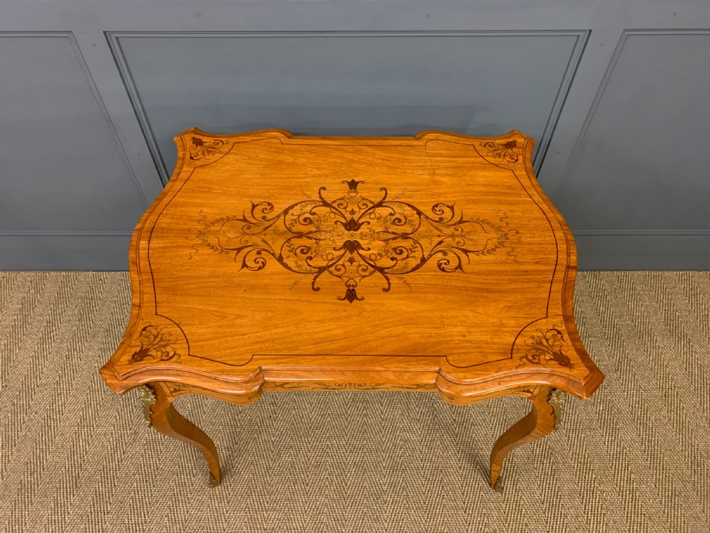 A 19th-century satinwood side table featuring floral marquetry inlay, serpentine edges, curved cabriole legs, and brass corner mounts. View III