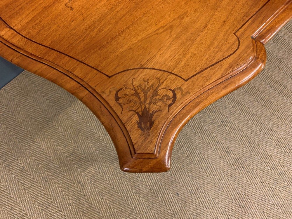 A 19th-century satinwood side table featuring floral marquetry inlay, serpentine edges, curved cabriole legs, and brass corner mounts. View IV