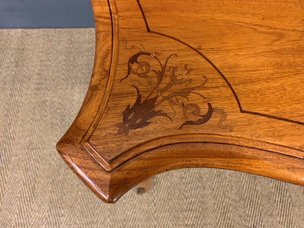 A 19th-century satinwood side table featuring floral marquetry inlay, serpentine edges, curved cabriole legs, and brass corner mounts. View V