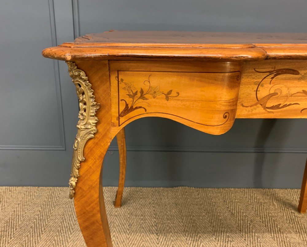 A 19th-century satinwood side table featuring floral marquetry inlay, serpentine edges, curved cabriole legs, and brass corner mounts. View VII