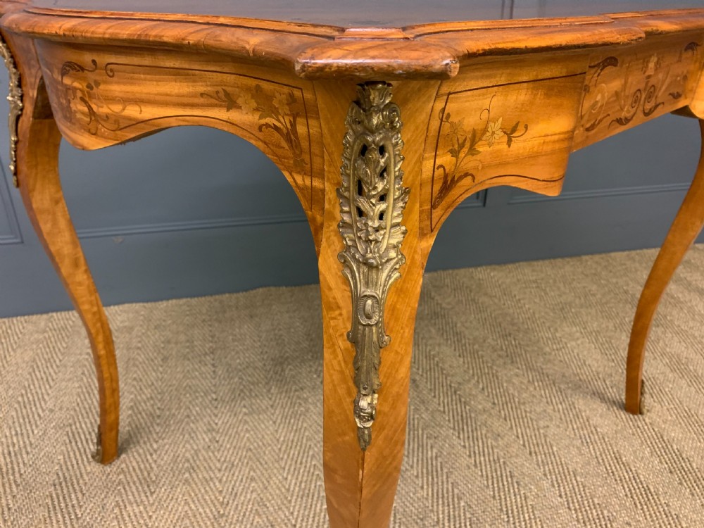 A 19th-century satinwood side table featuring floral marquetry inlay, serpentine edges, curved cabriole legs, and brass corner mounts. View IX