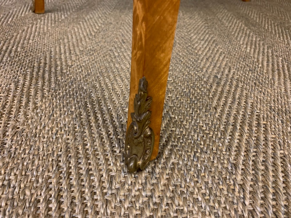 A 19th-century satinwood side table featuring floral marquetry inlay, serpentine edges, curved cabriole legs, and brass corner mounts. View X