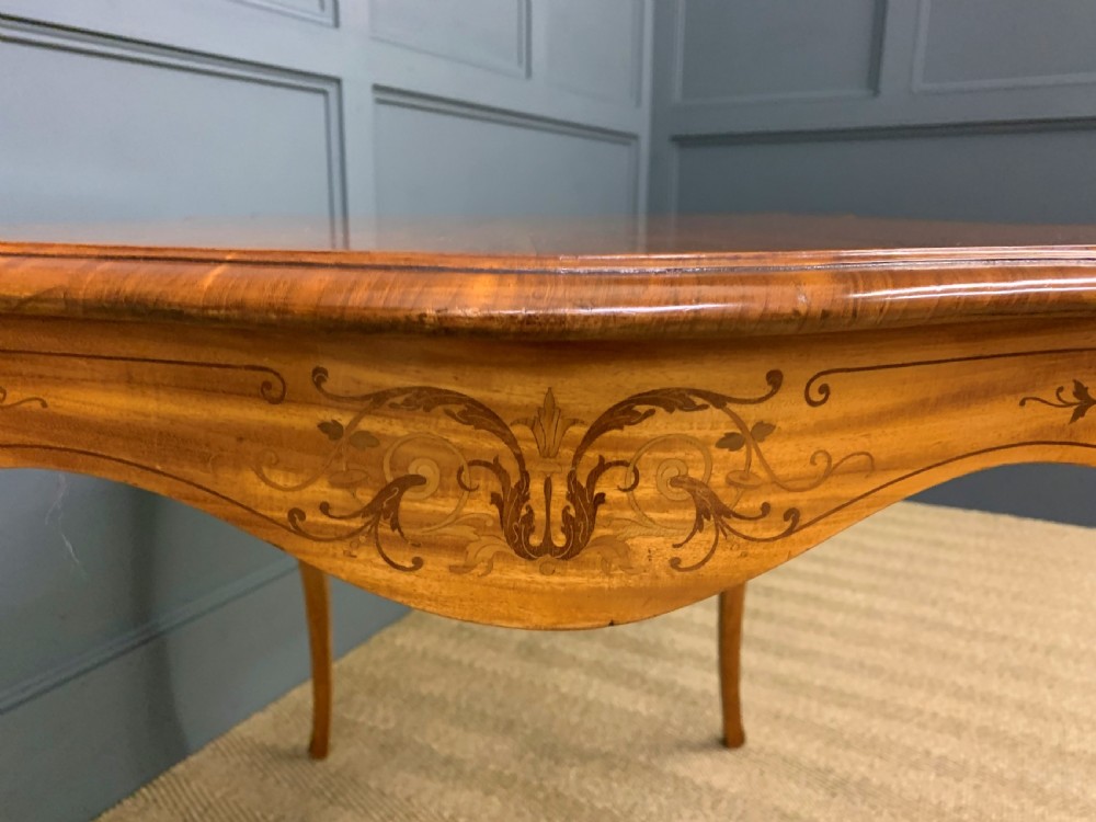 A 19th-century satinwood side table featuring floral marquetry inlay, serpentine edges, curved cabriole legs, and brass corner mounts. View XII