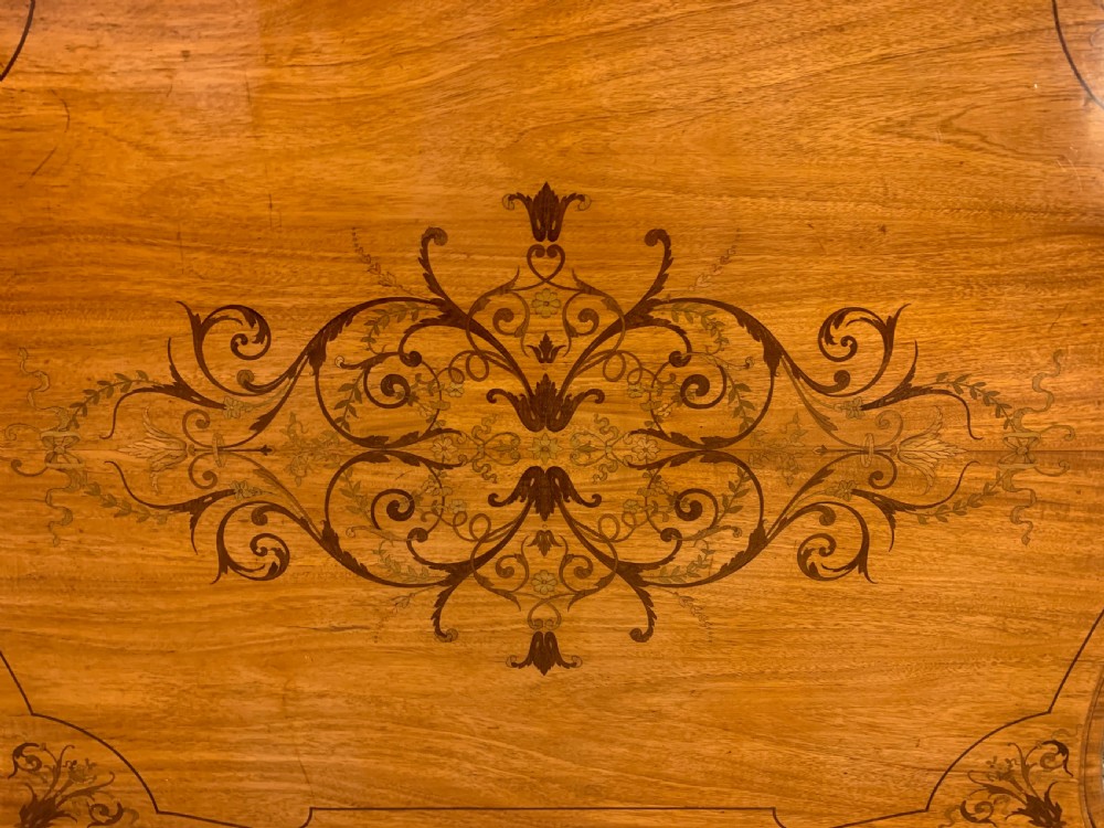 A 19th-century satinwood side table featuring floral marquetry inlay, serpentine edges, curved cabriole legs, and brass corner mounts. View XV