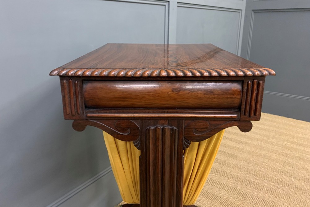 A Regency rosewood work table featuring a rectangular top with carved edging, a single drawer, a pleated yellow fabric storage well below, and trestle legs with brass castors. View XIII