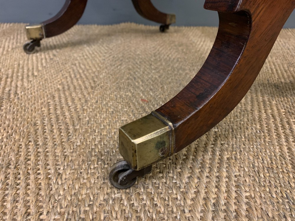 A Regency rosewood work table featuring a rectangular top with carved edging, a single drawer, a pleated yellow fabric storage well below, and trestle legs with brass castors. View XIV