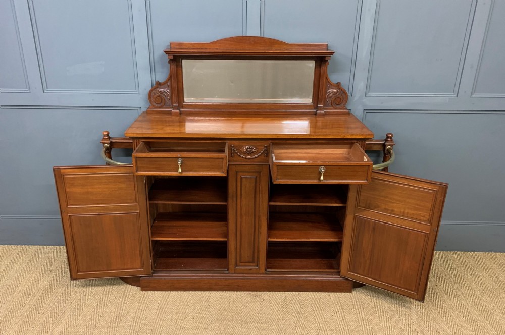 A Victorian walnut hall cupboard featuring a mirror back, two frieze drawers, panelled lower doors, and integrated side umbrella stands with brass rails. View III