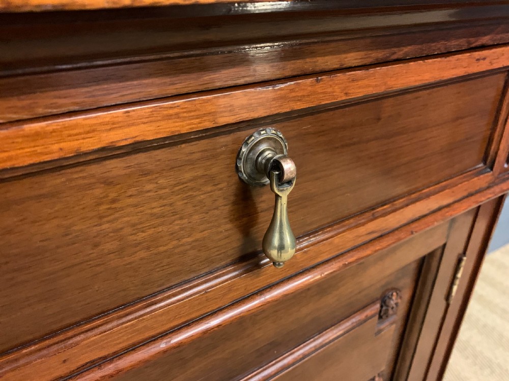 A Victorian walnut hall cupboard featuring a mirror back, two frieze drawers, panelled lower doors, and integrated side umbrella stands with brass rails. View VII