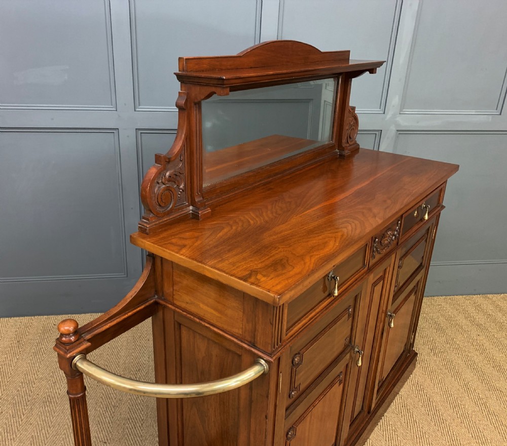 A Victorian walnut hall cupboard featuring a mirror back, two frieze drawers, panelled lower doors, and integrated side umbrella stands with brass rails. View X
