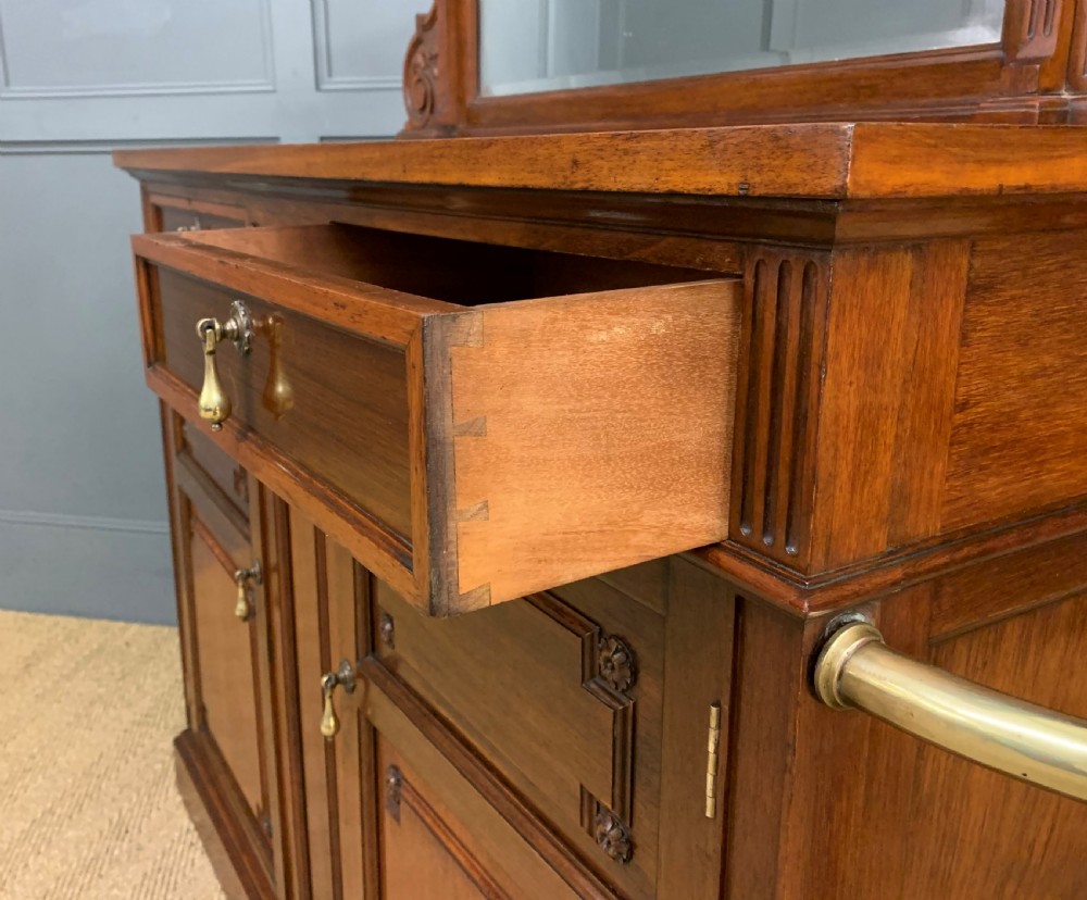 A Victorian walnut hall cupboard featuring a mirror back, two frieze drawers, panelled lower doors, and integrated side umbrella stands with brass rails. View XVI