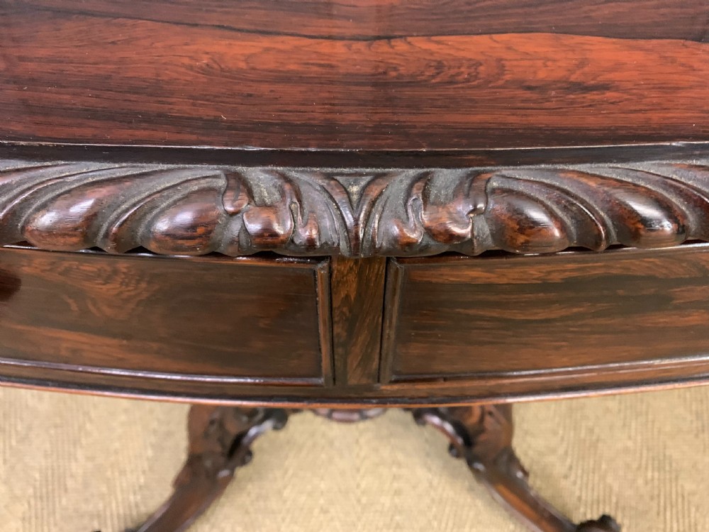 A 19th-century dark rosewood sofa table featuring drop leaves, two front frieze drawers, and an intricately carved central pedestal on scroll legs. View VI