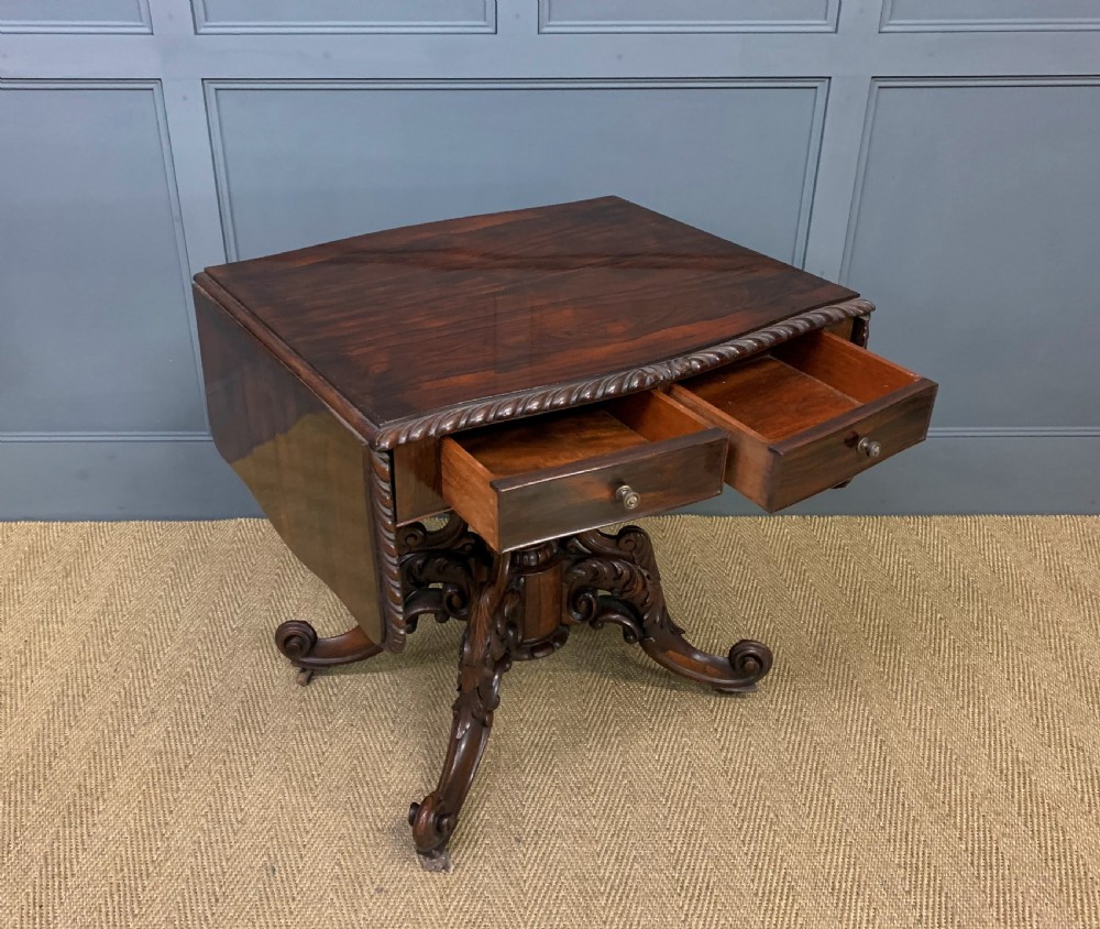 A 19th-century dark rosewood sofa table featuring drop leaves, two front frieze drawers, and an intricately carved central pedestal on scroll legs. View VIII