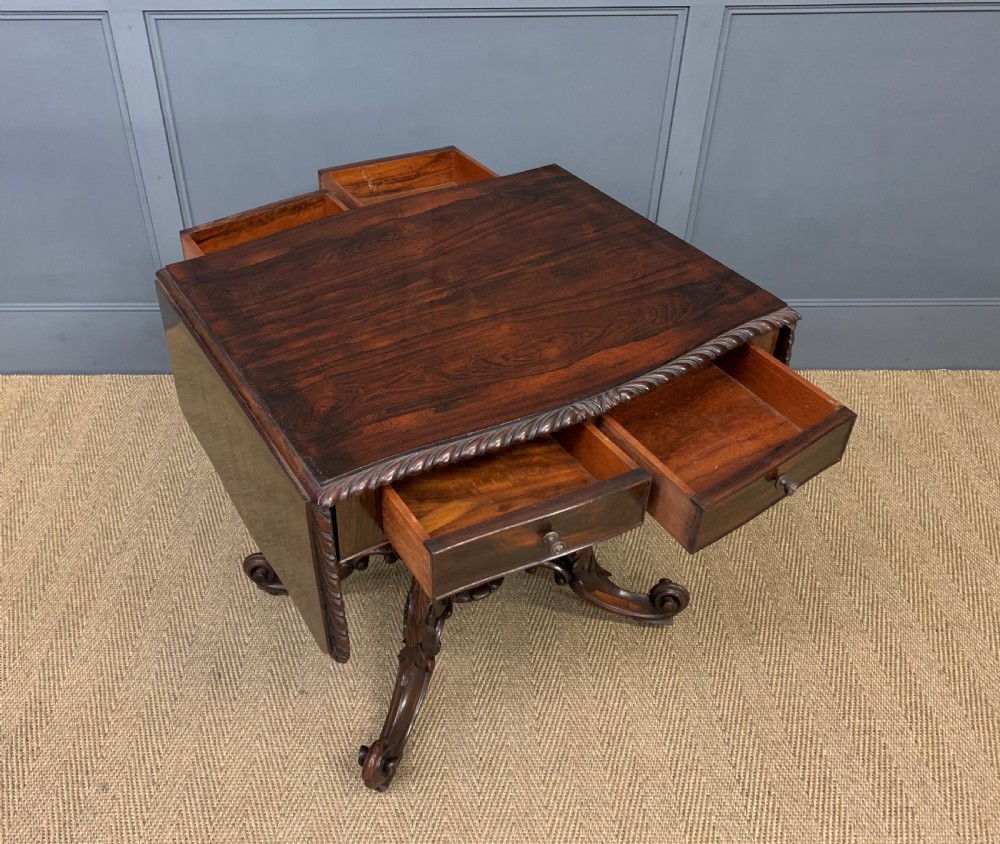 A 19th-century dark rosewood sofa table featuring drop leaves, two front frieze drawers, and an intricately carved central pedestal on scroll legs. View XI
