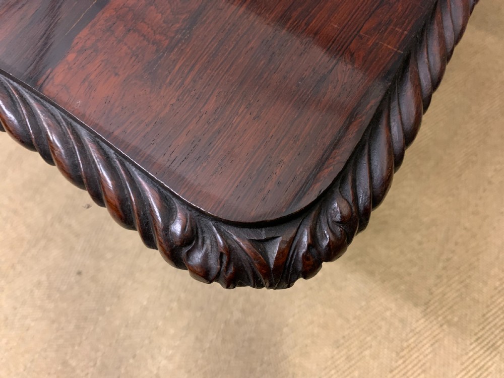 A 19th-century dark rosewood sofa table featuring drop leaves, two front frieze drawers, and an intricately carved central pedestal on scroll legs. View XXII
