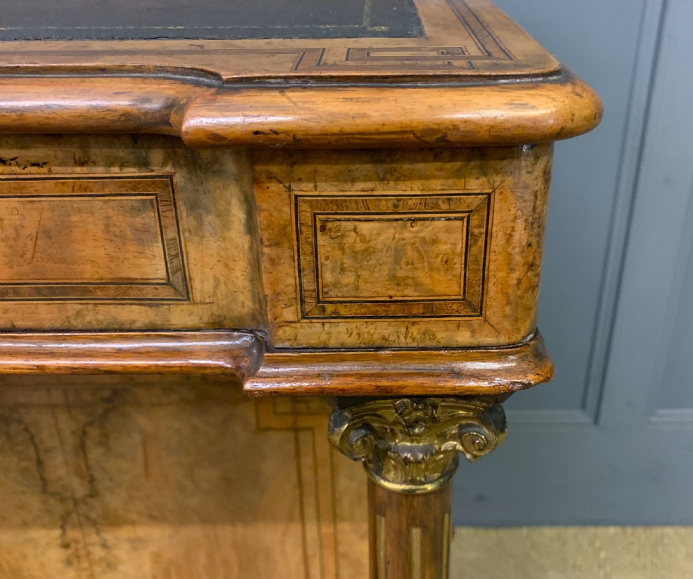 A Victorian burr walnut davenport desk featuring a sloped dark leather inset writing surface, brass gallery rail, side drawers, and fluted column supports. View VIII