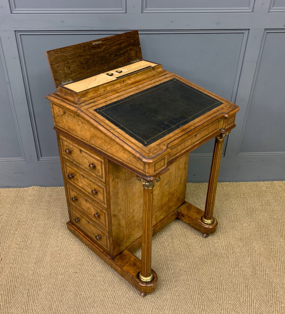 A Victorian burr walnut davenport desk featuring a sloped dark leather inset writing surface, brass gallery rail, side drawers, and fluted column supports. View XIII