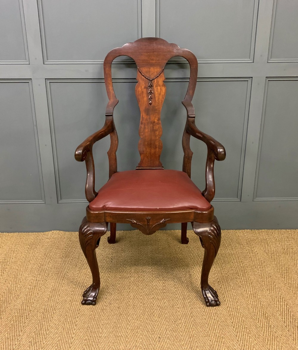A walnut high-back armchair featuring a carved back splat, reddish-brown leather seat, shaped arms, and carved cabriole legs ending in claw and ball feet. View II