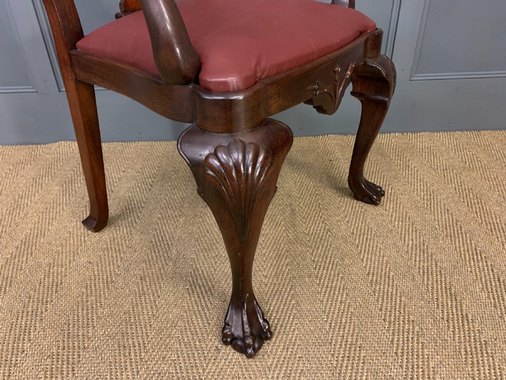 A walnut high-back armchair featuring a carved back splat, reddish-brown leather seat, shaped arms, and carved cabriole legs ending in claw and ball feet. View VIII