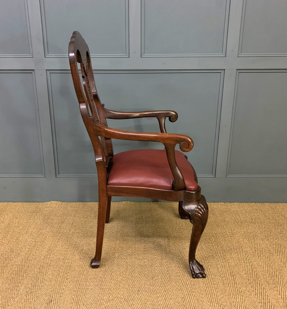 A walnut high-back armchair featuring a carved back splat, reddish-brown leather seat, shaped arms, and carved cabriole legs ending in claw and ball feet. View IX