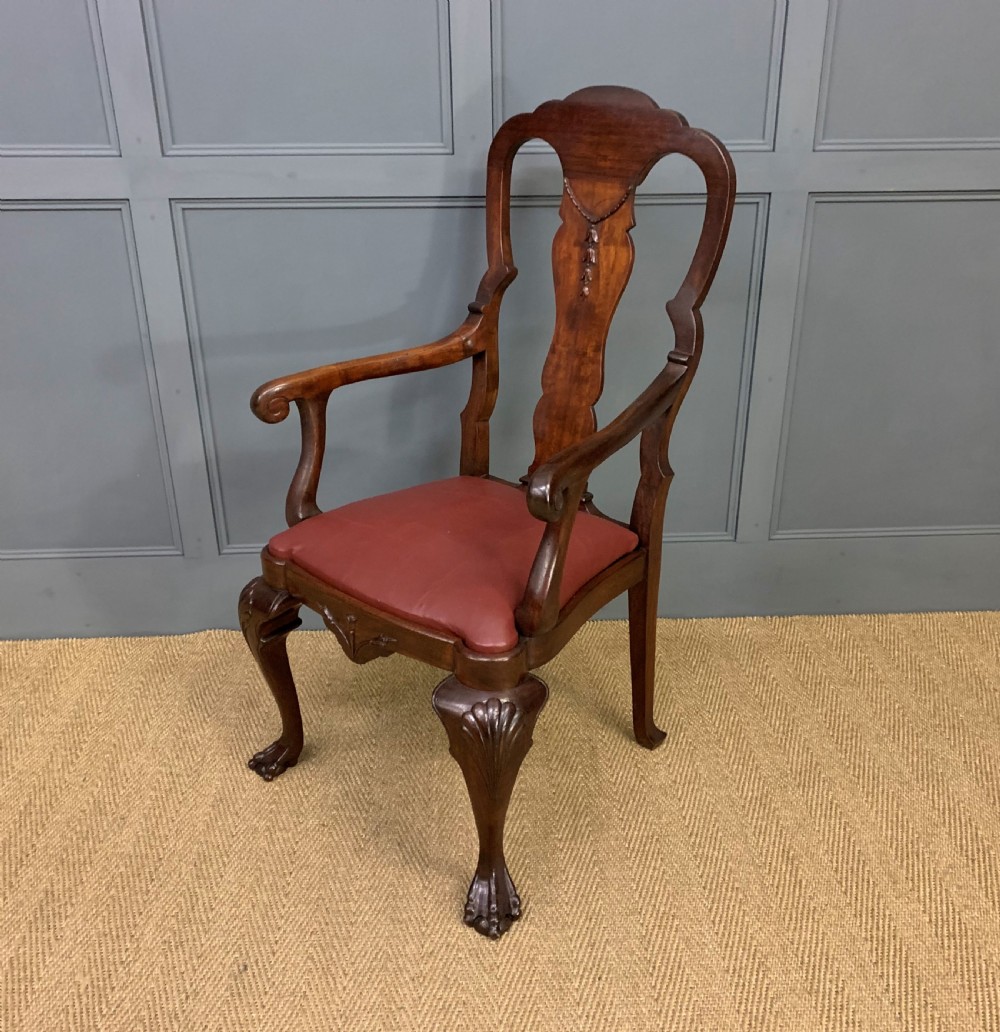 A walnut high-back armchair featuring a carved back splat, reddish-brown leather seat, shaped arms, and carved cabriole legs ending in claw and ball feet. View XI