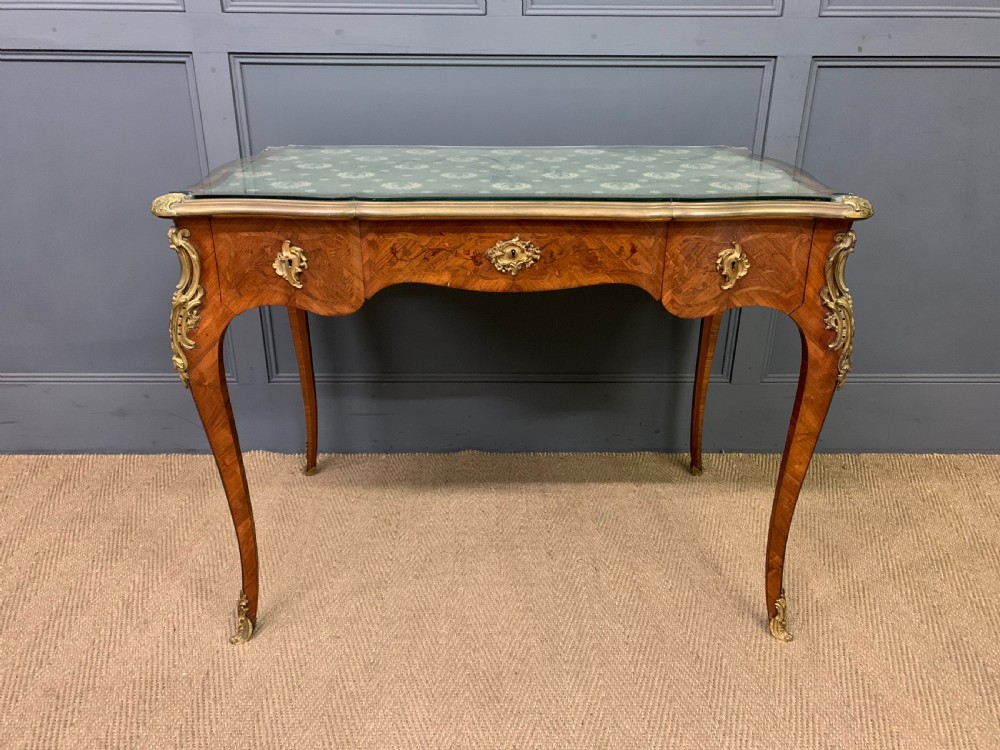 A French Louis XV style bureau plat featuring marquetry floral inlay, gilt-bronze mounts, cabriole legs, and a mint green patterned textile top under protective glass. View III