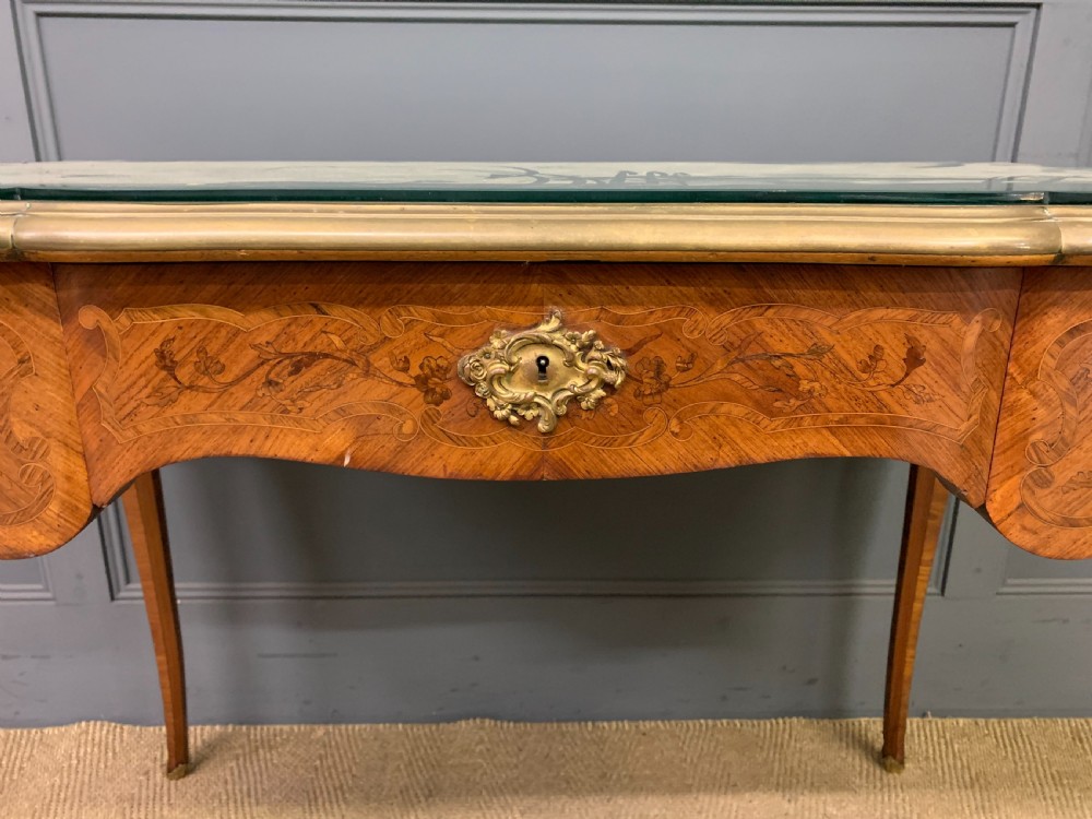 A French Louis XV style bureau plat featuring marquetry floral inlay, gilt-bronze mounts, cabriole legs, and a mint green patterned textile top under protective glass. View VI