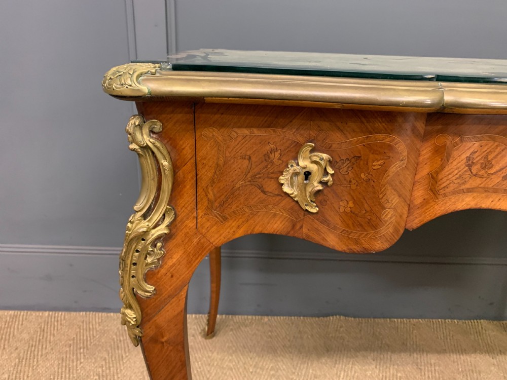A French Louis XV style bureau plat featuring marquetry floral inlay, gilt-bronze mounts, cabriole legs, and a mint green patterned textile top under protective glass. View VII