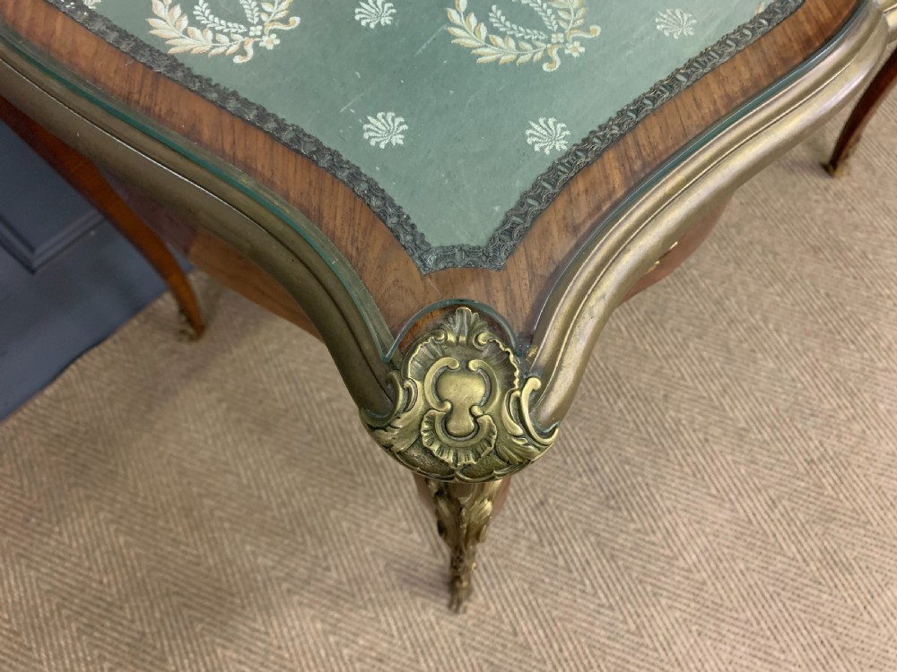 A French Louis XV style bureau plat featuring marquetry floral inlay, gilt-bronze mounts, cabriole legs, and a mint green patterned textile top under protective glass. View IX