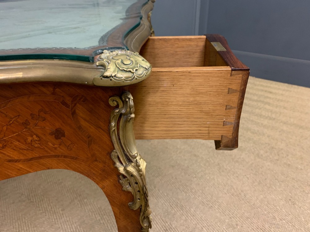 A French Louis XV style bureau plat featuring marquetry floral inlay, gilt-bronze mounts, cabriole legs, and a mint green patterned textile top under protective glass. View XII