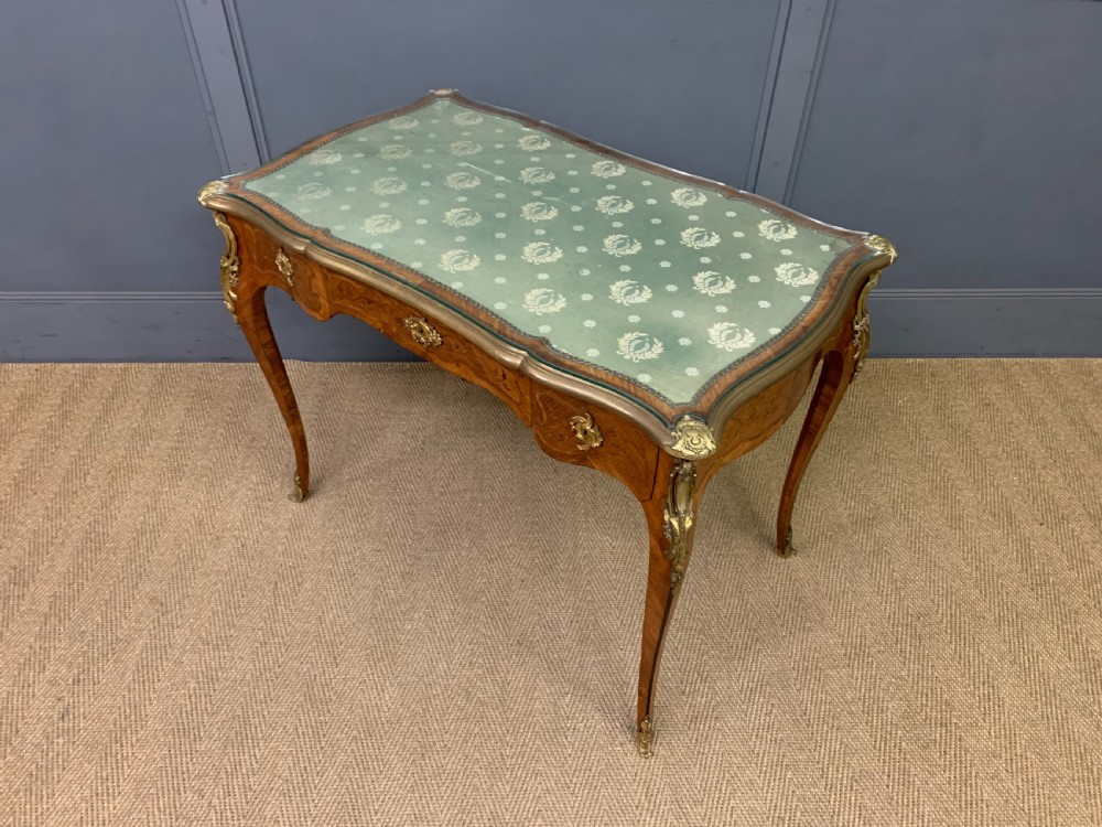 A French Louis XV style bureau plat featuring marquetry floral inlay, gilt-bronze mounts, cabriole legs, and a mint green patterned textile top under protective glass. View XIV