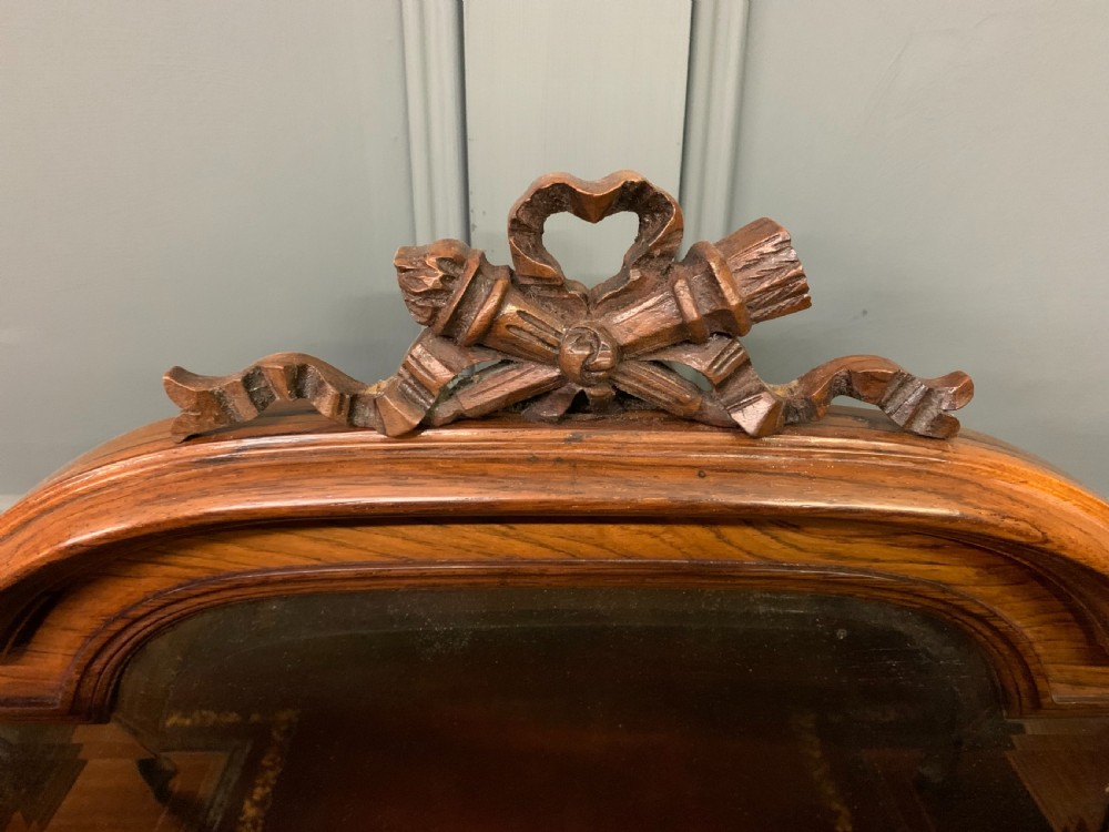 A Victorian mahogany writing desk featuring floral marquetry inlay, a gold-tooled leather insert, a raised superstructure with two drawers and a central mirror, resting on cabriole legs with brass castors. View VI