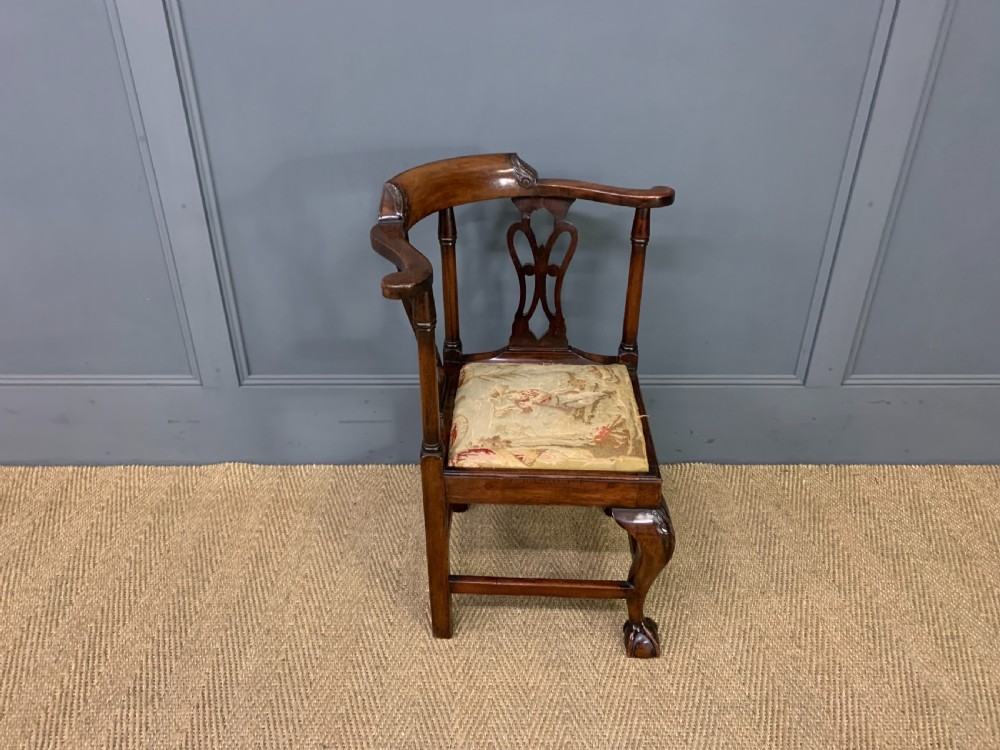A Georgian style walnut corner chair with a curved crest rail, pierced back splats, a tapestry seat pad, and a central cabriole front leg ending in a claw and ball foot. View VIII