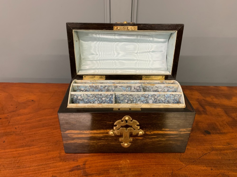 A Victorian dome-topped stationery casket crafted from dark variegated coromandel wood, decorated with pierced brass strapwork and a blue and white ceramic cameo inset. View X