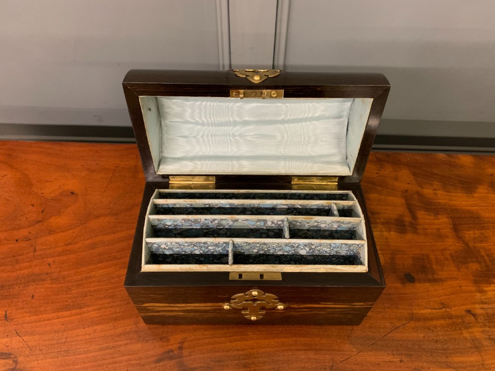A Victorian dome-topped stationery casket crafted from dark variegated coromandel wood, decorated with pierced brass strapwork and a blue and white ceramic cameo inset. View XI
