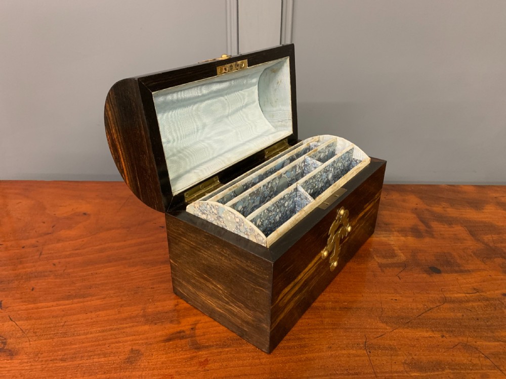 A Victorian dome-topped stationery casket crafted from dark variegated coromandel wood, decorated with pierced brass strapwork and a blue and white ceramic cameo inset. View XII