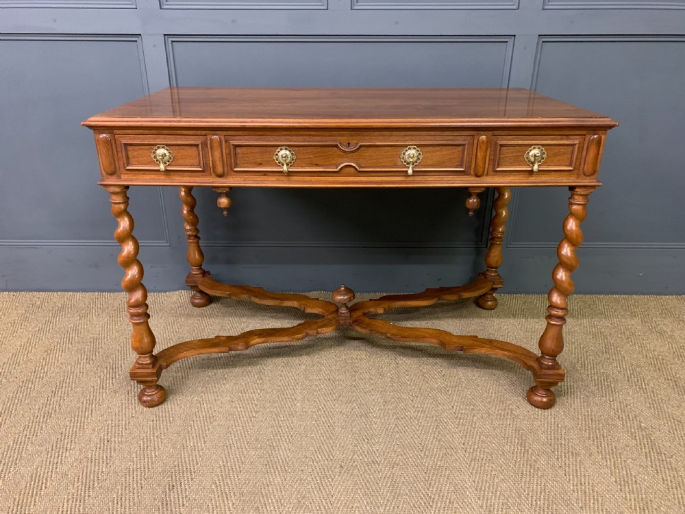 A rectangular walnut side table featuring three drawers with brass teardrop drop-handles, spiral barley twist legs, and a serpentine X-stretcher with a central turned finial. View II