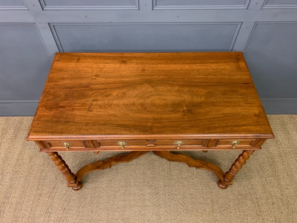 A rectangular walnut side table featuring three drawers with brass teardrop drop-handles, spiral barley twist legs, and a serpentine X-stretcher with a central turned finial. View III