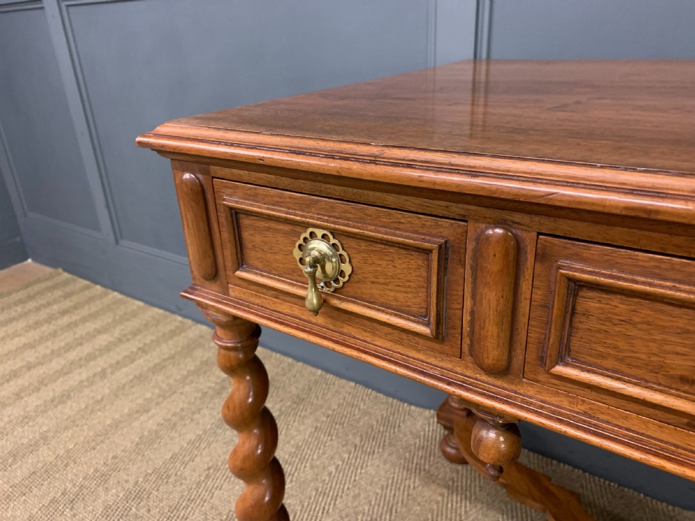 A rectangular walnut side table featuring three drawers with brass teardrop drop-handles, spiral barley twist legs, and a serpentine X-stretcher with a central turned finial. View IV