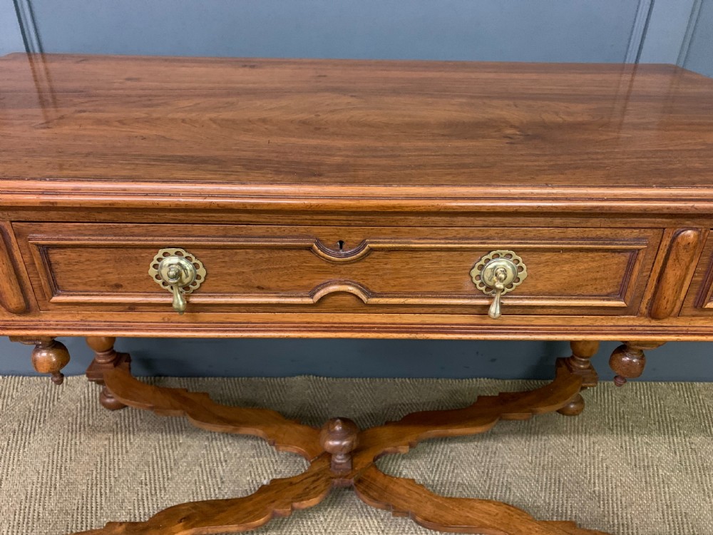 A rectangular walnut side table featuring three drawers with brass teardrop drop-handles, spiral barley twist legs, and a serpentine X-stretcher with a central turned finial. View VII