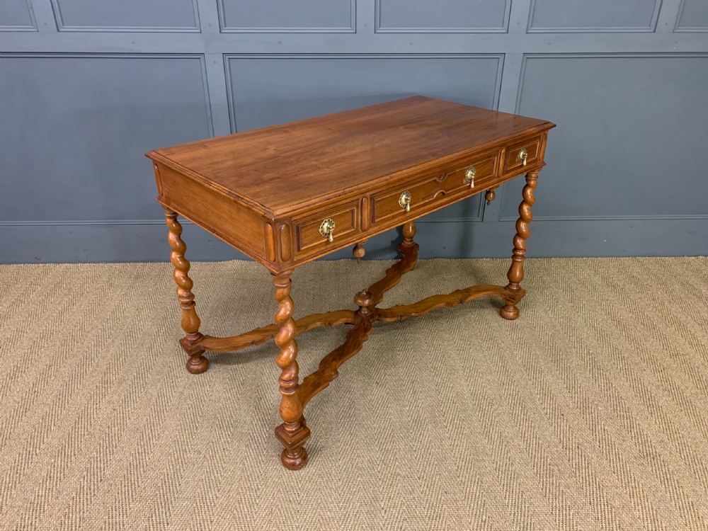 A rectangular walnut side table featuring three drawers with brass teardrop drop-handles, spiral barley twist legs, and a serpentine X-stretcher with a central turned finial. View XI