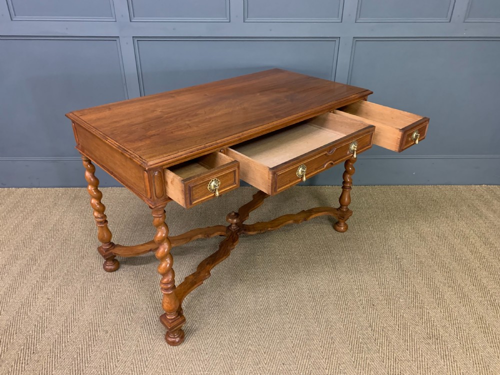A rectangular walnut side table featuring three drawers with brass teardrop drop-handles, spiral barley twist legs, and a serpentine X-stretcher with a central turned finial. View XV