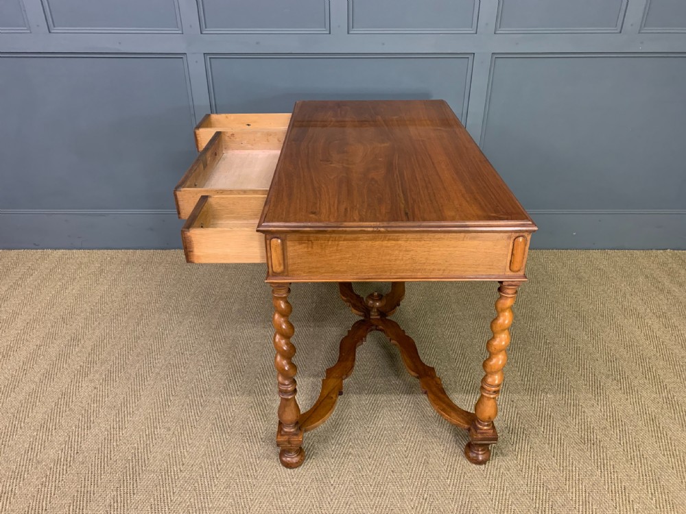 A rectangular walnut side table featuring three drawers with brass teardrop drop-handles, spiral barley twist legs, and a serpentine X-stretcher with a central turned finial. View XVII