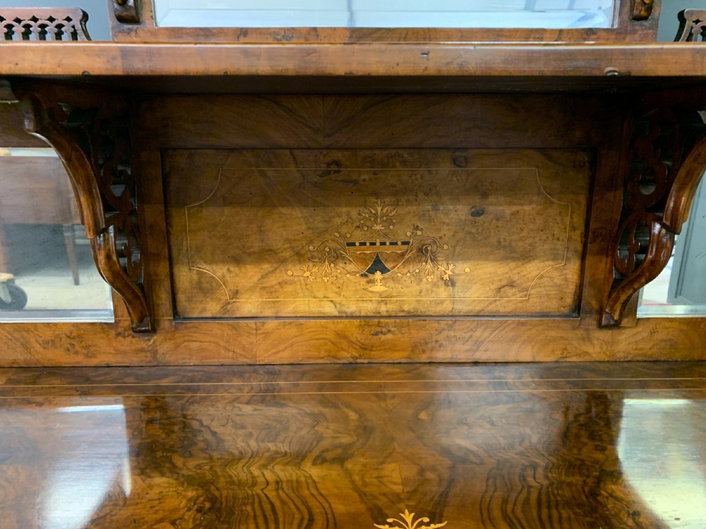 A Victorian burr walnut chiffonier featuring a central cabinet door with floral marquetry, open side tiers with turned spindles, and an upper structure with mirror panels and gallery railings. View VIII