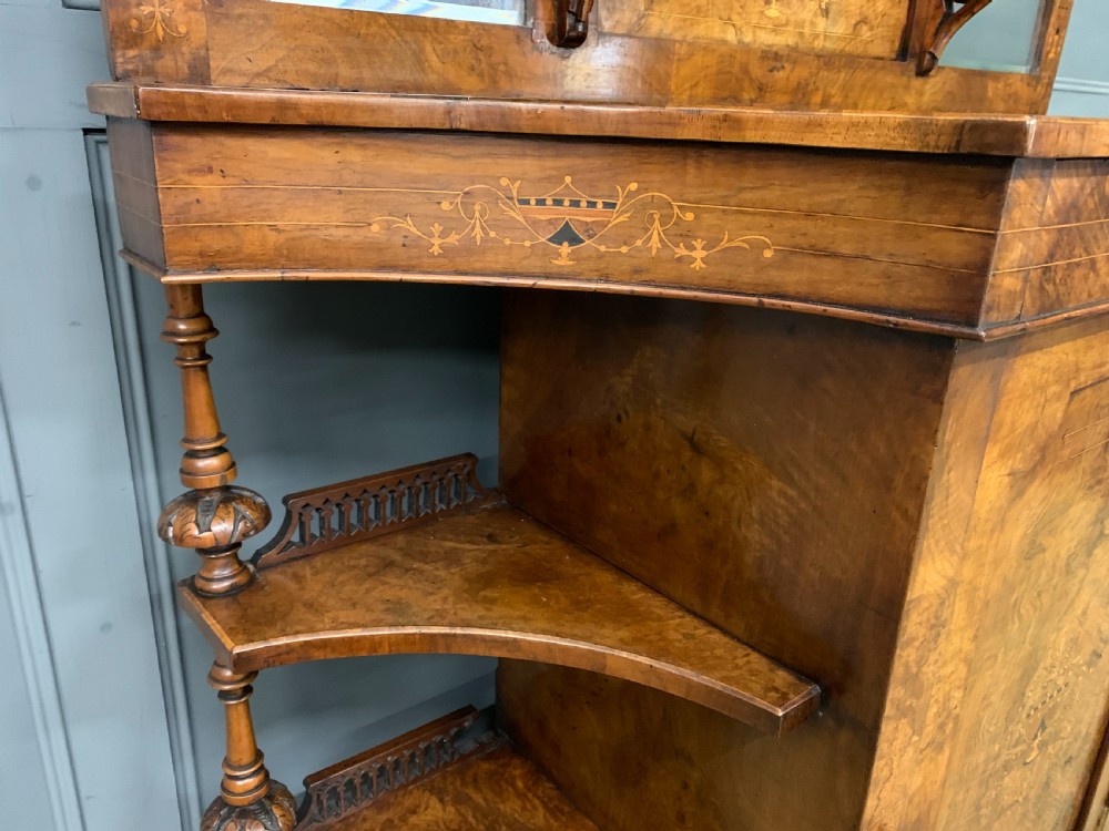 A Victorian burr walnut chiffonier featuring a central cabinet door with floral marquetry, open side tiers with turned spindles, and an upper structure with mirror panels and gallery railings. View XI