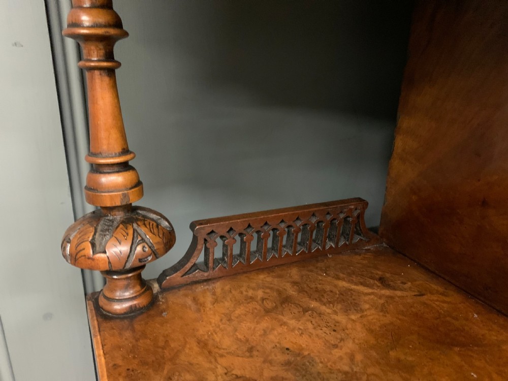 A Victorian burr walnut chiffonier featuring a central cabinet door with floral marquetry, open side tiers with turned spindles, and an upper structure with mirror panels and gallery railings. View XII