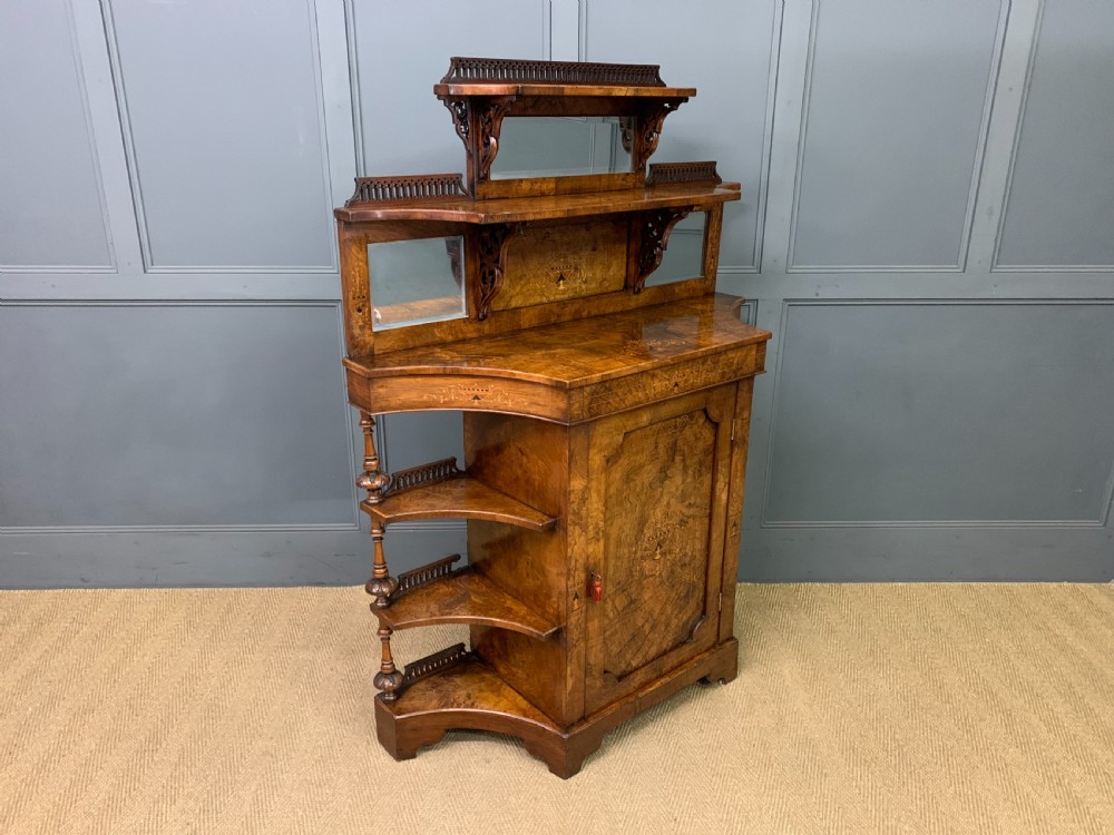 A Victorian burr walnut chiffonier featuring a central cabinet door with floral marquetry, open side tiers with turned spindles, and an upper structure with mirror panels and gallery railings. View XIII