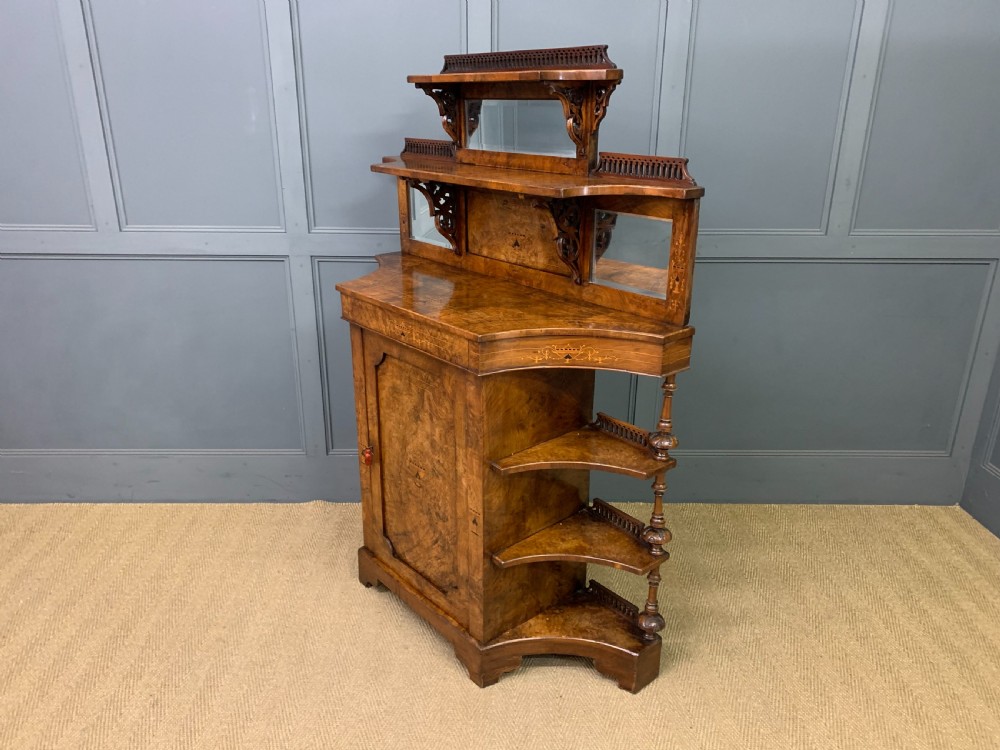 A Victorian burr walnut chiffonier featuring a central cabinet door with floral marquetry, open side tiers with turned spindles, and an upper structure with mirror panels and gallery railings. View XVII
